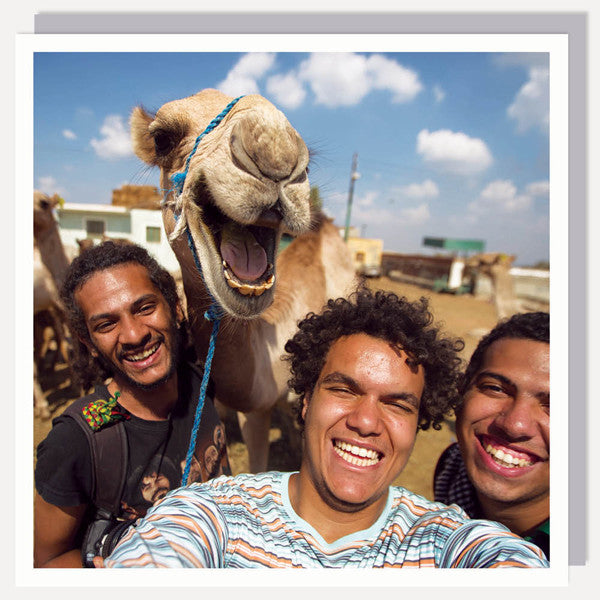 greetings card - 3 smiling men taking a selfie with a smiling camel