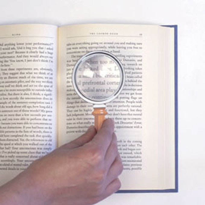 a hand demonstrating Fresnel Bookmark use with a book
